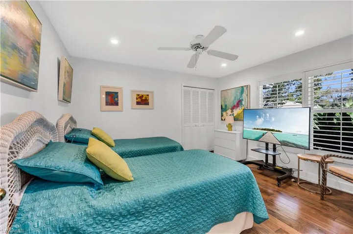 Bedroom with a closet, hardwood / wood-style flooring, ceiling fan, and recessed lighting