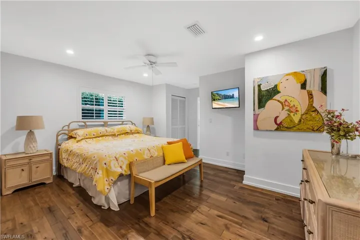 Bedroom with dark wood-type flooring, a closet, recessed lighting, and a ceiling fan