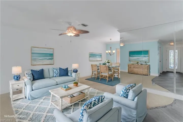 Virtually staged Living room with ceiling fan, a chandelier, and ornamental molding