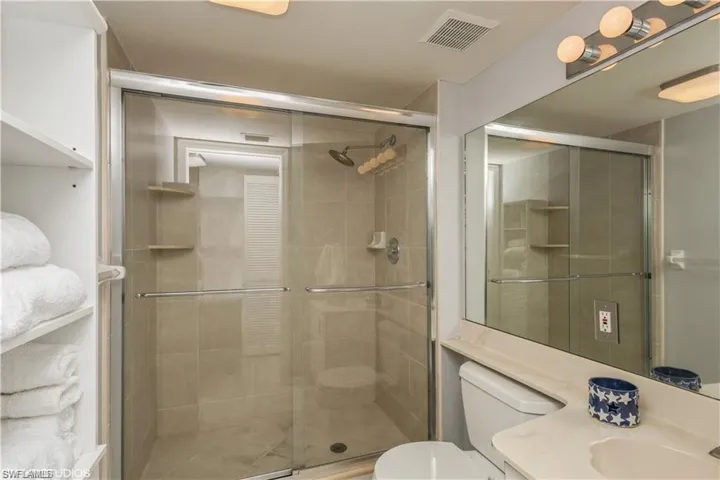 Newer guest shower with glass shower doors.