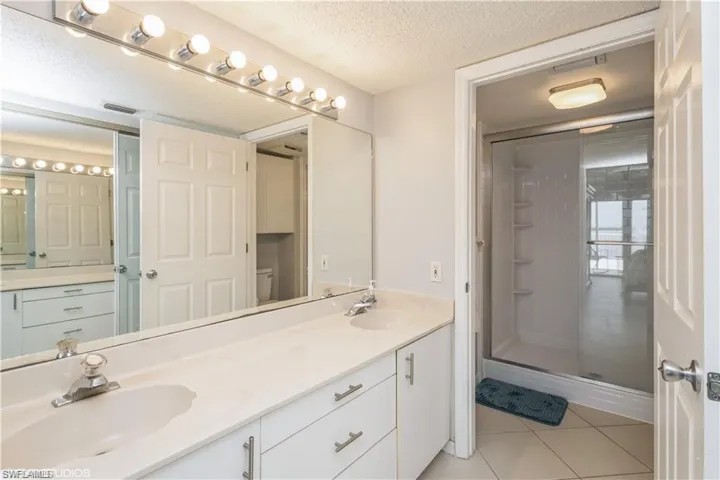 Main bath with dual sinks and separate shower room.