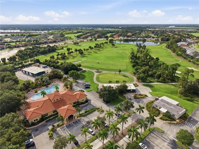Expansive golf course property featuring multiple greens, a clubhouse with a terracotta tile roof, and a resort-style swimming pool