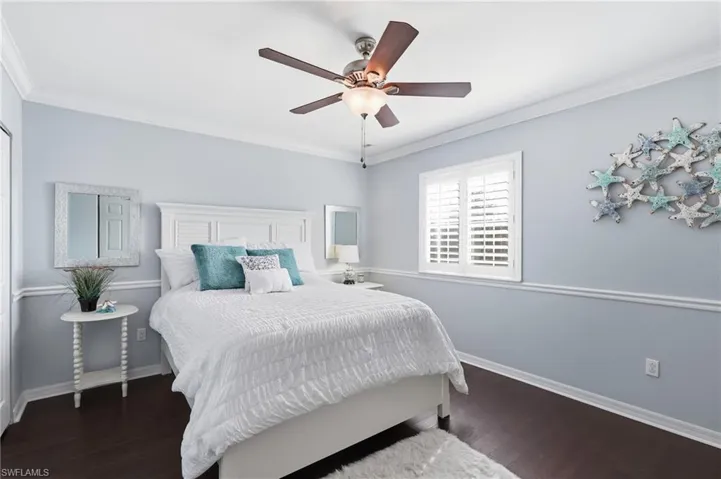 White paneled headboard with dark wood-finish flooring