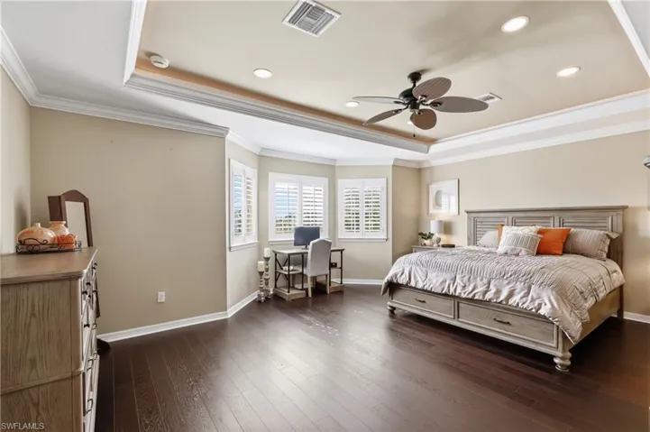 Spacious room featuring dark wood-finish flooring and light beige walls