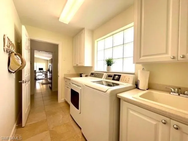 Laundry room with cabinets, sink, and independent washer and dryer