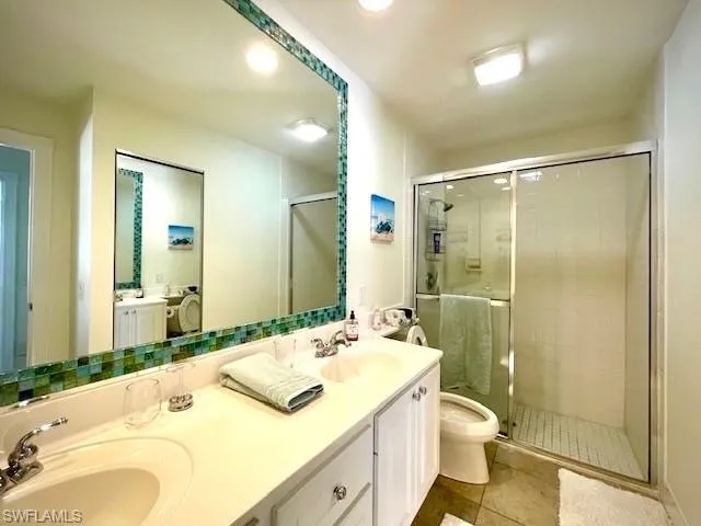 Bathroom with vanity, toilet, tile patterned floors, and walk in shower