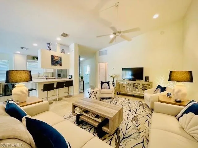 Living room featuring lofted ceiling, sink, and ceiling fan