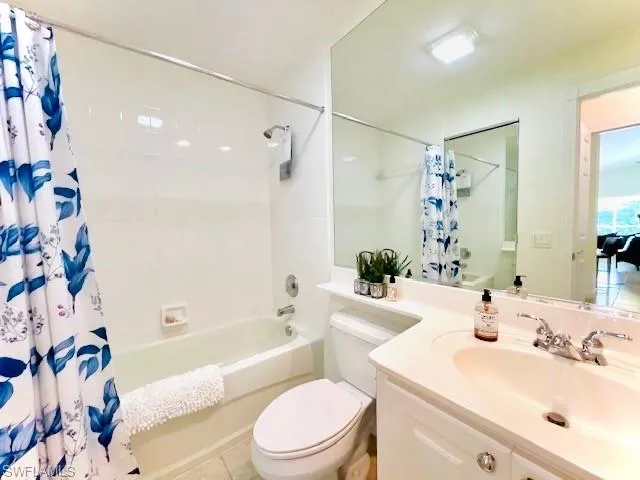 Full bathroom featuring shower / tub combo with curtain, vanity, and toilet