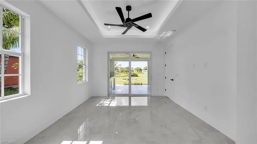 Unfurnished room with a raised ceiling, ceiling fan, and recessed lighting