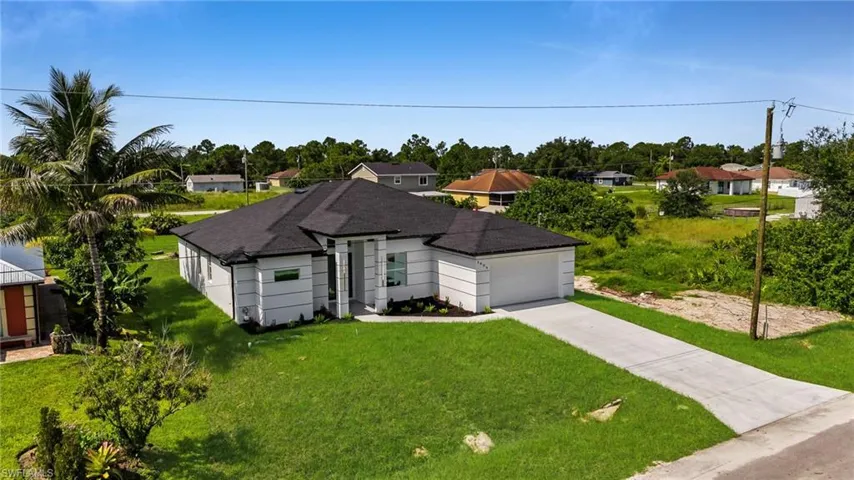 View of front facade featuring concrete driveway, a garage, a front lawn, and a residential view