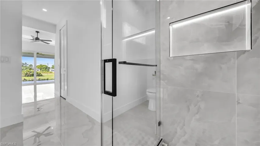 Full bathroom with a marble finish shower and a ceiling fan