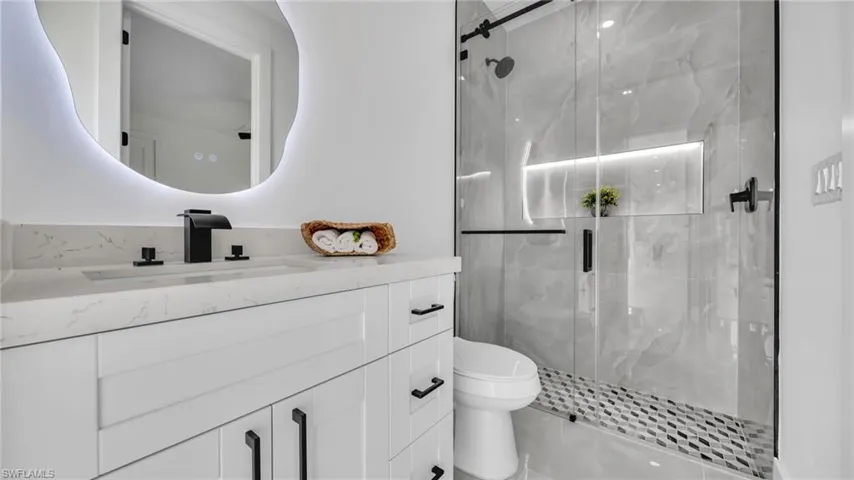 Full bathroom featuring vanity and a marble finish shower