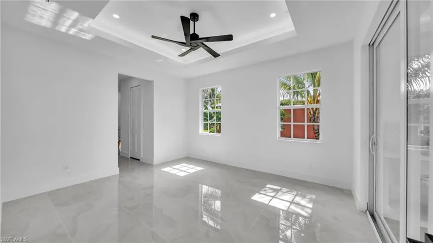 Unfurnished room featuring a raised ceiling, recessed lighting, and a ceiling fan