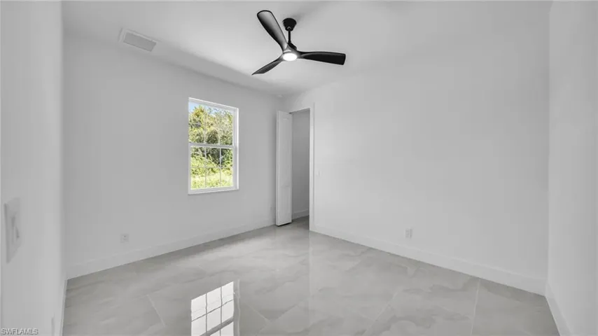 Spare room with a ceiling fan and baseboards