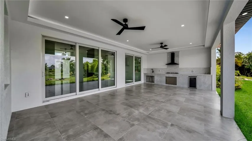View of patio / terrace with a ceiling fan, exterior kitchen, and wine cooler