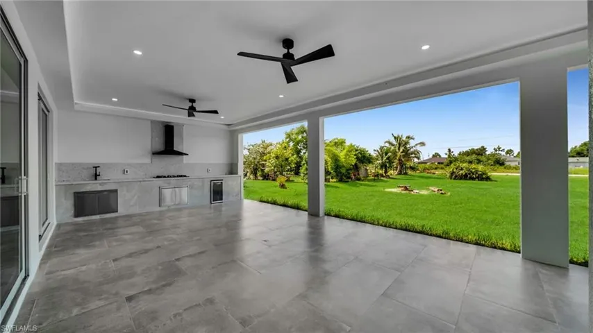 View of patio with a ceiling fan, area for grilling, and wine cooler