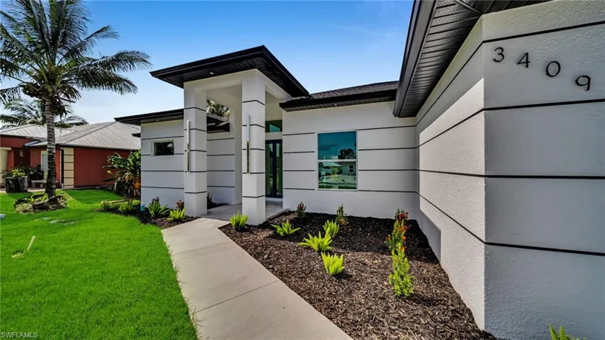 Property entrance featuring a yard and stucco siding