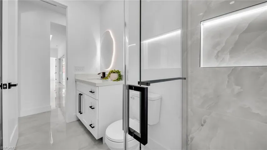 Full bath featuring vanity and marble finish floors