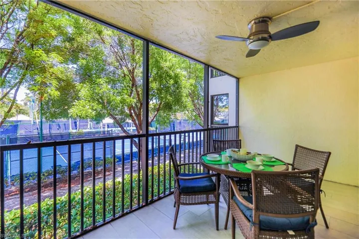 Sunroom with a balcony and a ceiling fan