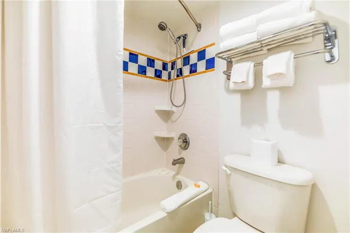 Bathroom with shower / tub combo with curtain and toilet