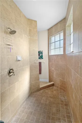 Full bathroom with tiled shower and tile patterned flooring