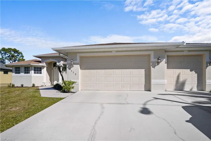 View of front of house with driveway, stucco siding, a front lawn, and 3 car garage. the home has a classy two tone paint and newer roof. A very well maintained home!