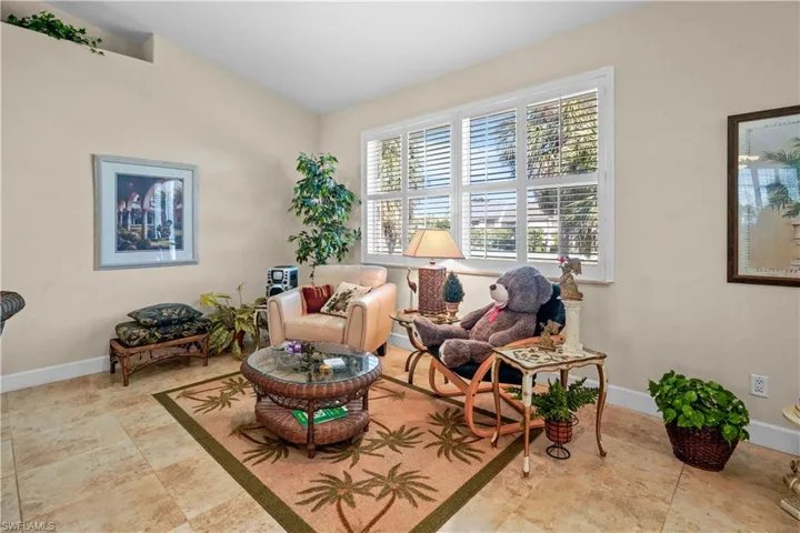 The great room has enough space for multiple sitting areas. The owners used to have a pool table in this area. Features 5 3/4" base boards and Wooded plantation shutters on huricane windows adn valuted ceilings.