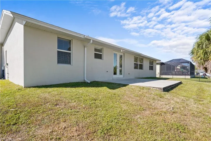 Back of property featuring a patio area, french doors, stucco siding, and concrete patio.