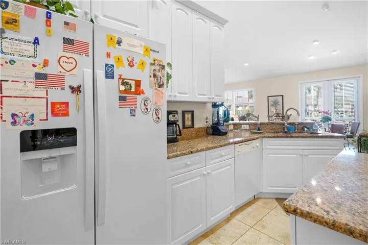 Kitchen featuring white appliances, 42" high white cabinets with crown molding, beautiful granite countertops, large pantry great natural light open to the great room formal dining area and casual dining area. Laudry room and garage enterence are off the kitchen.
