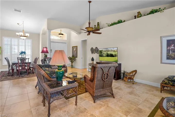 Living area featuring high vaulted ceiling, a ceiling fan, chandeliers.
