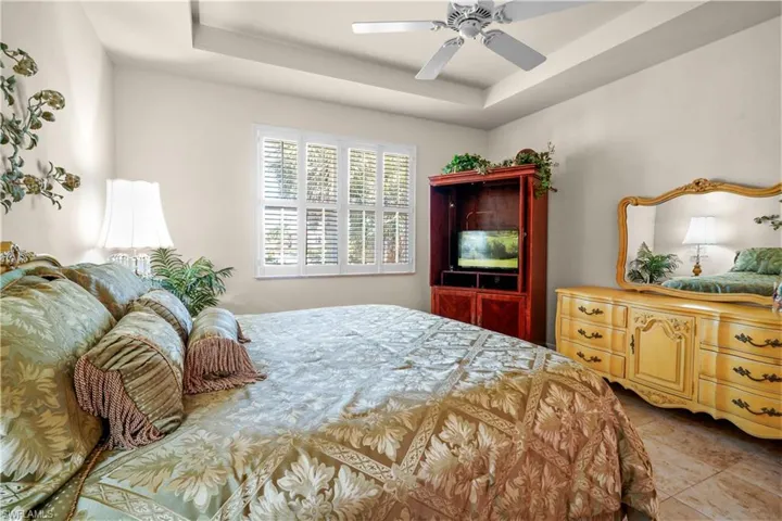 Spacious primay bedroom that is 20' x 13' with nice natural lighting from hurricane windows with plantation shutters. High trayed ceiling, 20" porcelain tile, 5 3/4' base board and ceiling fan.