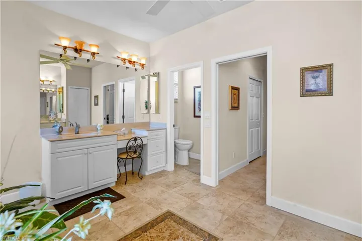 Nicely appointed primary bathroom. It is very spacious with jtwo seperate vanities one side includes a dressing table and drawer large mirror with double lights.