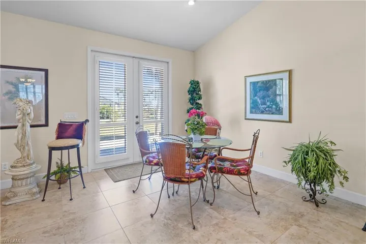 The casual dining area off the kitchen features French doors and a vaulted ceiling.