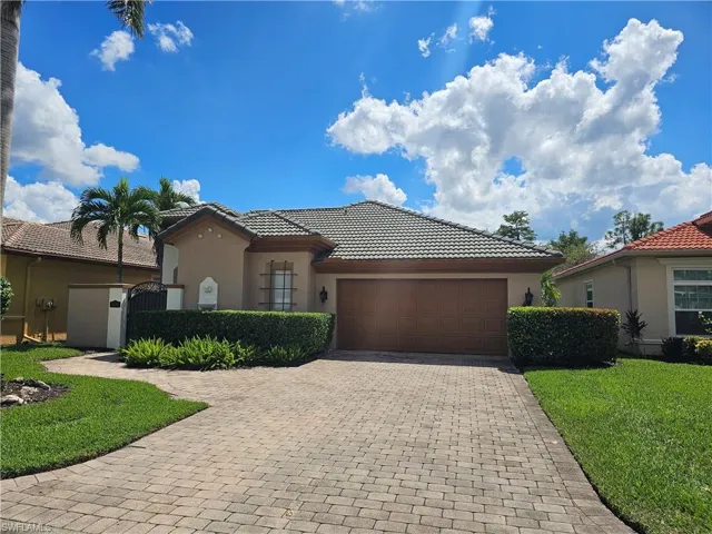 Mediterranean / spanish-style home featuring stucco siding, a tile roof, a gate, and decorative driveway