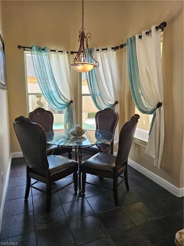 Dining area with baseboards and stone tile floors
