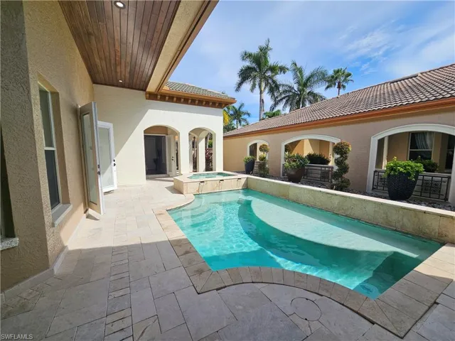 View of pool featuring a patio and a pool with connected hot tub