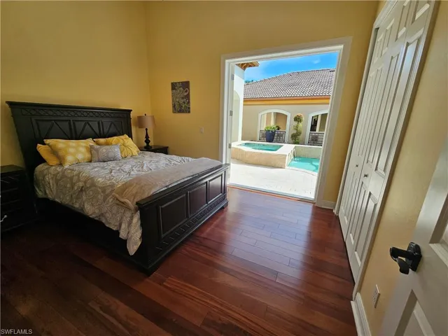 Bedroom featuring dark wood-type flooring, access to outside, and a closet