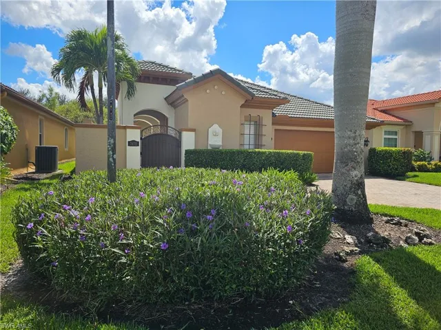 Mediterranean / spanish-style home with a tiled roof, an attached garage, stucco siding, driveway, and a gate