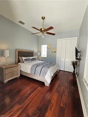 Bedroom featuring a closet, dark wood-style flooring, and ceiling fan