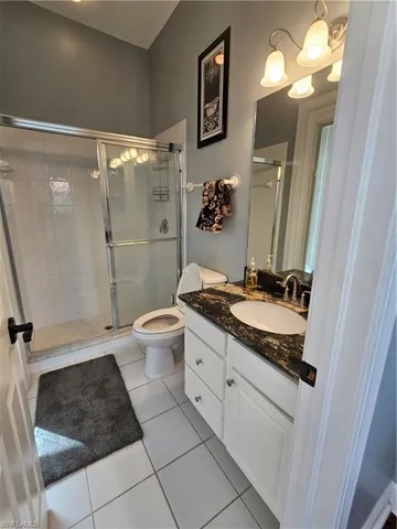Bathroom with vanity, a stall shower, and light tile patterned floors
