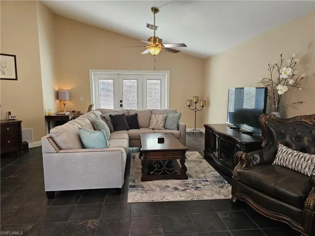 Living room with a ceiling fan and high vaulted ceiling