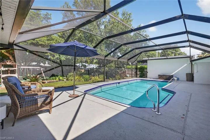 Swimming pool with a lanai, a sunroom, and a patio area