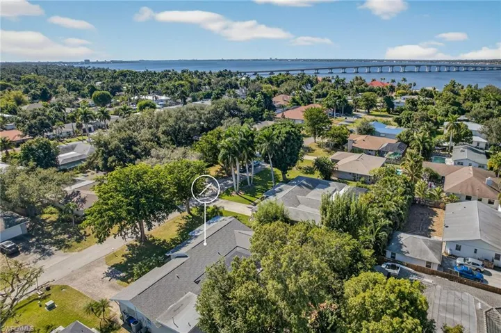 Aerial perspective of suburban area featuring a notable bridge and a large body of water