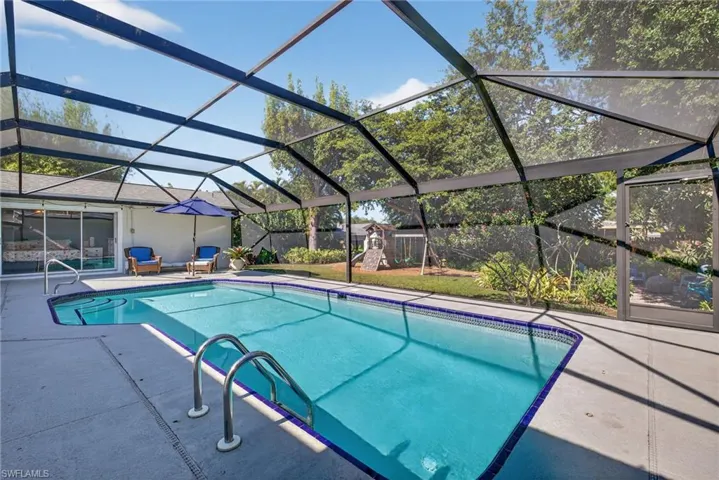 Swimming pool with a lanai, a sunroom, a patio area, and a playground