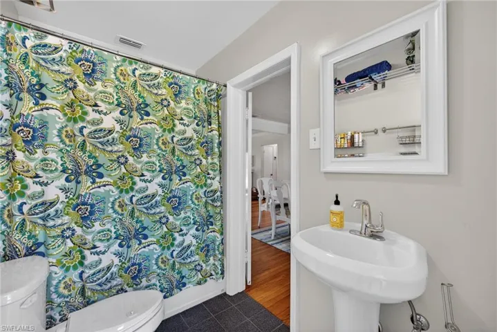 Bathroom featuring toilet and a shower with curtain