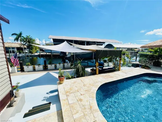 View of swimming pool with a patio, a dock, and a water view