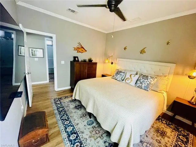 Bedroom featuring ornamental molding, hardwood / wood-style flooring, and ceiling fan