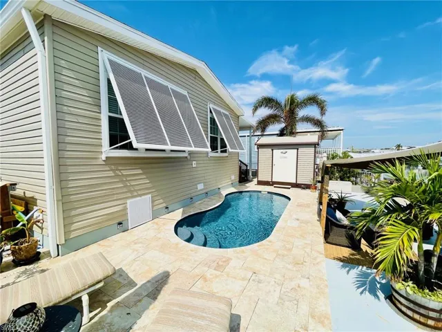 View of pool with a patio area and a storage shed