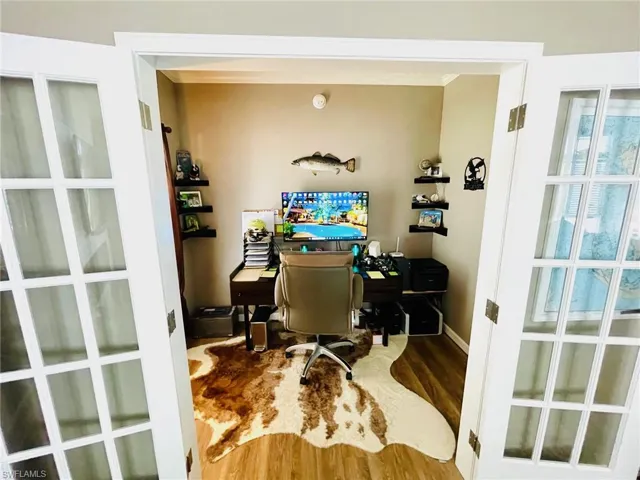 Office area with ornamental molding and hardwood / wood-style floors