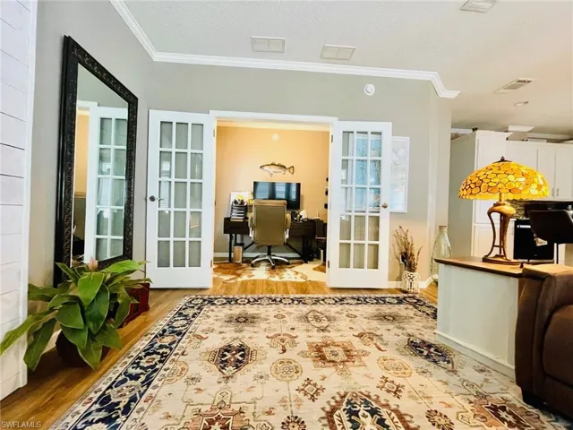Doorway with french doors, light hardwood / wood-style flooring, and crown molding